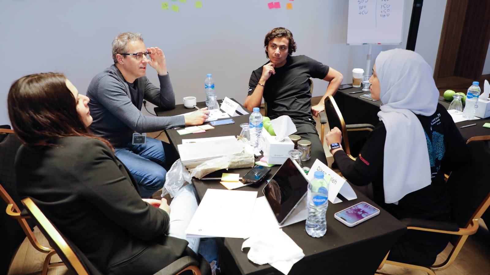 A small leadership cohort working with notes and a whiteboard